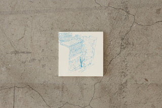 Thick cream notebook open to light blue line drawing across the page.