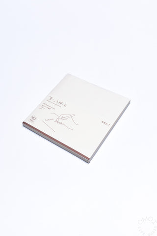 White cotton notebook with printed cover illustrations and brown spine edge