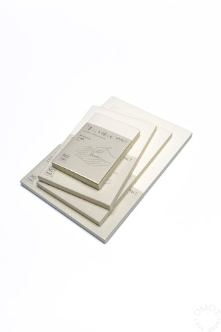 Set of lined notebooks stacked together with small note cards on top.