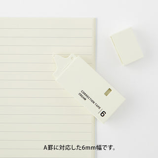 White 6mm correction tape dispenser with strip positioned on lined page