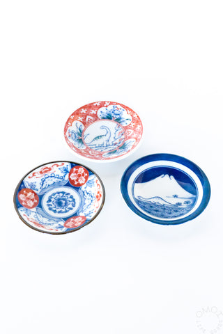 Assorted mini ceramic plates: blue mountain design and red patterned plate