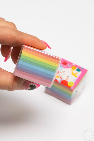 Mini origami papers stacked in rainbow colors, held in hand