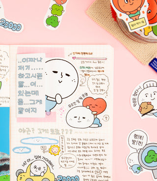 Notebook with cartoon character stickers and a hand placing a sticker