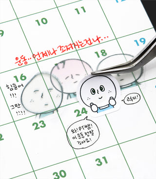 Close-up of a round character face sticker on a calendar grid with dates