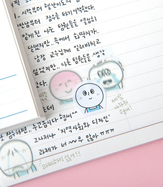Close-up of round character face stickers with speech bubbles and a tweezer tip