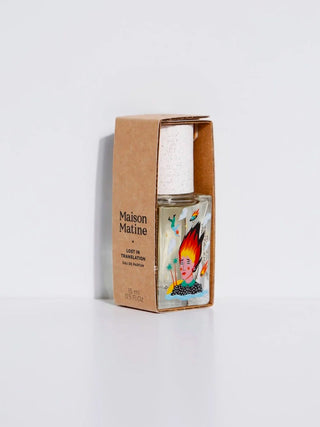 Perfume bottle in kraft paper box with illustrated label, small glass vial.