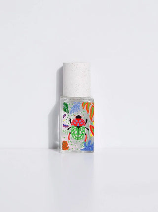 Eau de parfum bottle with speckled cap and colorful graphic label, 15 ml size