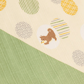 Furoshiki close-up with cream diagonal section showing shiba dog, striped marks, and wave icons