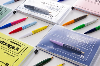 Mini ballpoint pens in assorted colors in a clear storage display case
