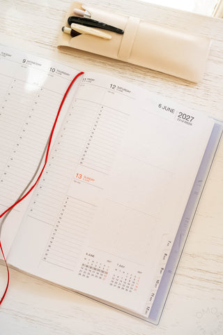 Open weekly vertical planner pages with date grid and red highlight line, 2027