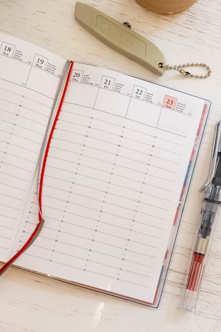 A6 weekly vertical planner refill open showing weekly grid days and dates