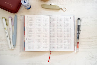 A6 weekly vertical planner refill open to a multi-week calendar grid page