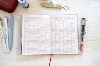 A6 weekly vertical planner refill open showing two calendar grids with colored highlights