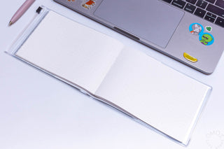 Open landscape dot grid notebook with blank dotted pages and silver binding