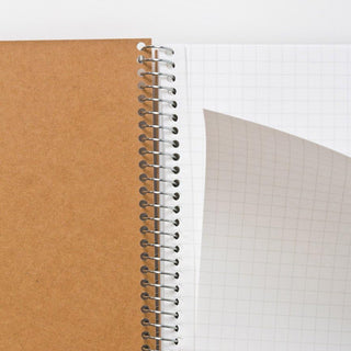 B5 spiral notebook spine close-up between kraft cover and grid paper