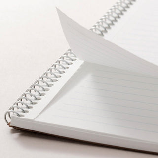 B5 spiral notebook open view with lined pages and metal coil binding