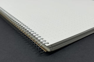 B5 spiral ring notebook detail, metal coil binding along the notebook edge