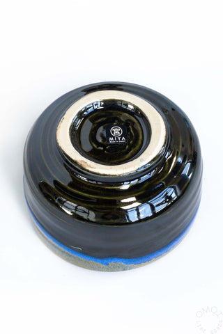Ceramic matcha chawan bowl, glossy black interior with stamped logo and blue glaze edge