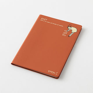 Midori 2027 B7 monthly planner, orange cover with character graphic and date heading
