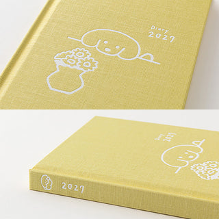 Close-up of yellow cover with 2027 date and fluffy dog line-art