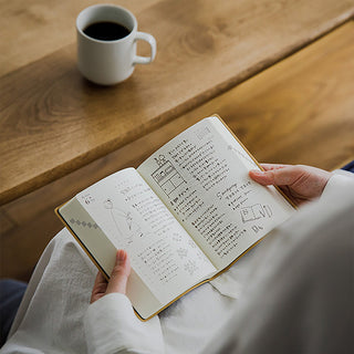 Open A6 two-page-a-day planner with printed daily pages and diagrams