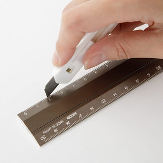 Brown aluminum multi ruler with printed scales and pivot joint, held by hand