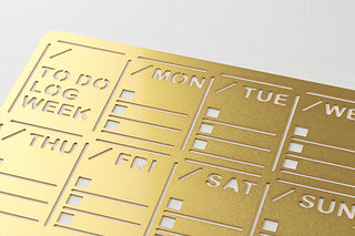 Brass-gold weekly diary template close-up with day columns and lined to-do areas