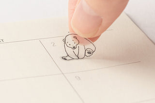 Sea animal planner sticker being applied by hand to a notebook page