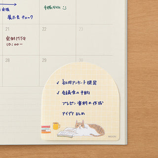 Cat sticky note pad on planner page, beige grid with cat scene and check list