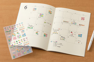 Floral planner sticker set shown beside an open calendar notebook
