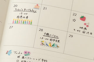 Planner calendar page with small strawberry and star stickers on dated squares