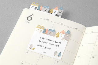Town illustrated sticky notes sheet placed on a weekly calendar page