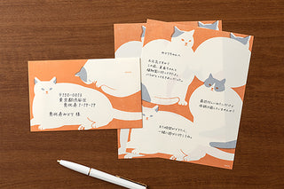 Cat stationery set showing letter sheets and envelopes with orange-and-white cat designs