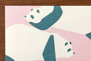 Close-up view of panda letter paper, teal pandas over pink and cream stripes