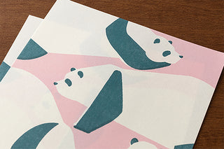 Close-up of panda letter paper with teal panda shapes on pink-and-cream background