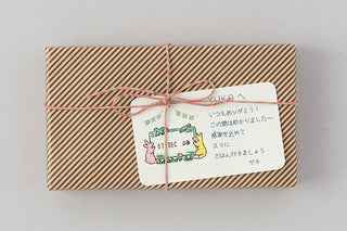 Gift-wrapped package with a stamped label featuring a forest animal and date