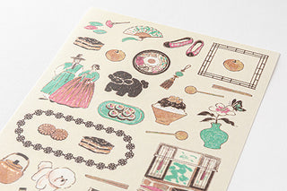 Close-up of vintage Korea-themed sticker sheet with food, figures, and decorative frames