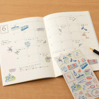 Planner calendar spread with Dutch-themed sticker sheet showing icons and small scenes