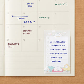 Lined sticky note sheet with dog graphic, placed on planner with handwritten entries