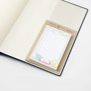 Sticky notes pad partially inserted in planner, kraft cover with fluffy dog design