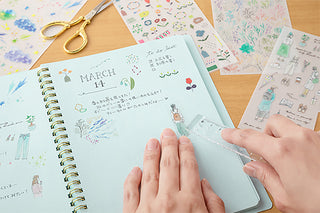 Starry sky transfer stickers being applied to a planner page