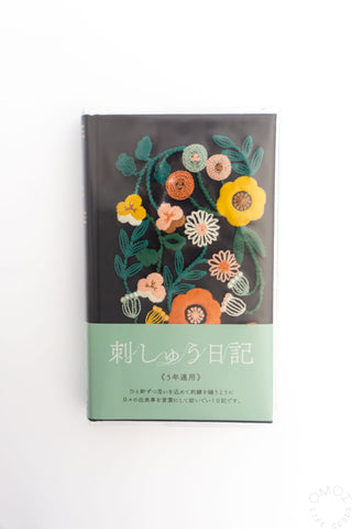 Green 5-year diary with multicolor floral embroidery on the cover and text strip