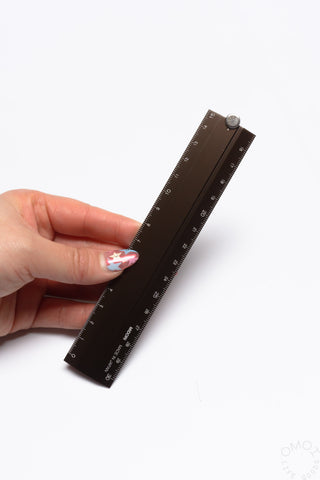 Brown aluminum multi ruler with inch and metric scales and metal pivot knob