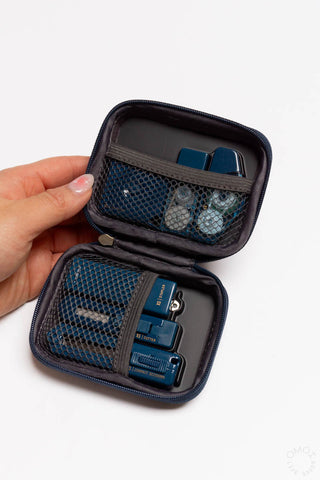 Hand holding open teal mini stationery kit with zip pouch and mesh tool pockets