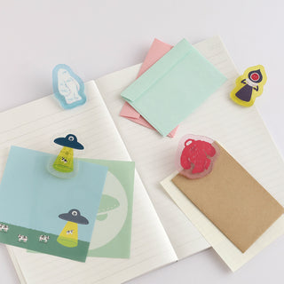 Set of acrylic clips on notebooks, including a red Bigfoot design
