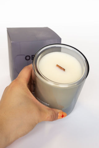 Obake candle in glass jar held in hand, cream wax with visible wick
