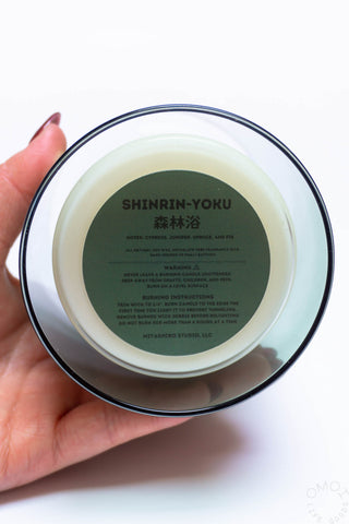 Candle base underside with SHINRIN-YOKU text and product information label.