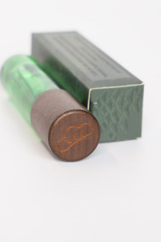 Green skin scent tube with brown cap and gray gift box