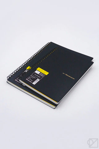 Black spiral notebook with dot grid pages and yellow label on the cover