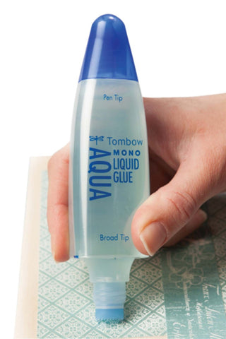 Tombow Mono Aqua liquid glue pen held by hand, broad tip visible